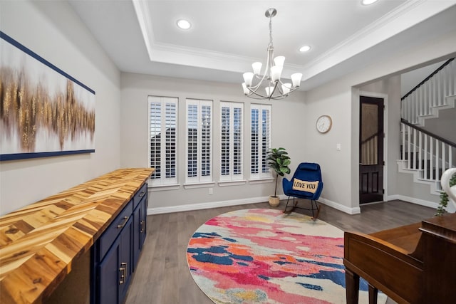 sitting room featuring dark hardwood / wood-style flooring, a raised ceiling, and ornamental molding