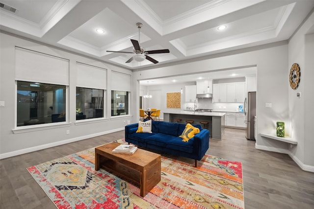 living room with ceiling fan with notable chandelier, beamed ceiling, light hardwood / wood-style floors, and coffered ceiling