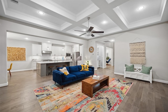 living room featuring coffered ceiling, ceiling fan, crown molding, beam ceiling, and hardwood / wood-style floors