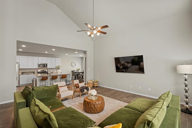 living room with ceiling fan, sink, high vaulted ceiling, and dark hardwood / wood-style floors