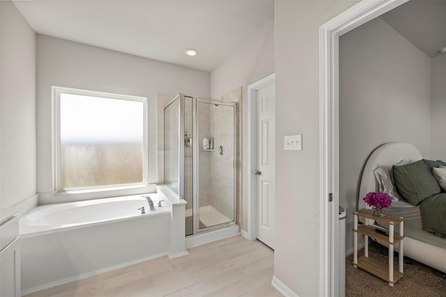 bathroom with wood-type flooring and independent shower and bath