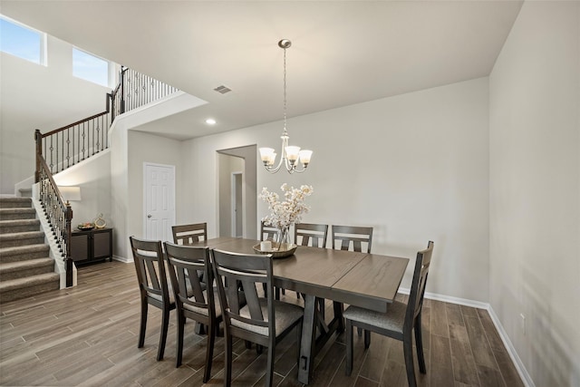 dining area featuring hardwood / wood-style floors and an inviting chandelier