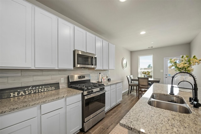 kitchen featuring white cabinets, appliances with stainless steel finishes, dark hardwood / wood-style flooring, and sink