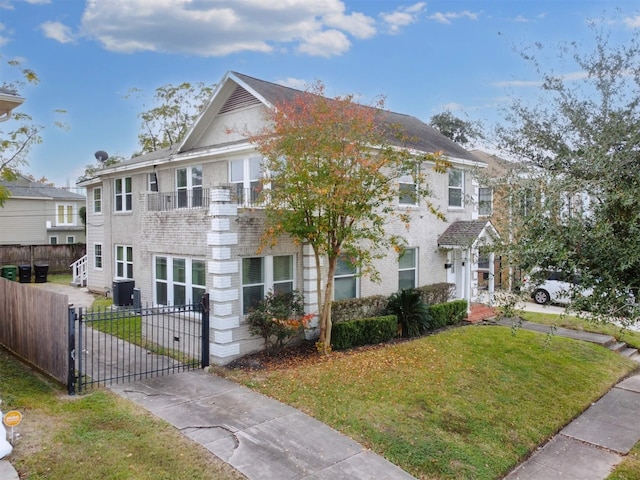 view of front of home featuring a balcony, central air condition unit, and a front lawn