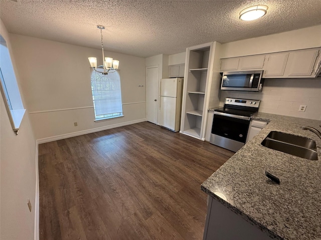 kitchen featuring stainless steel appliances, sink, decorative light fixtures, a chandelier, and dark hardwood / wood-style floors