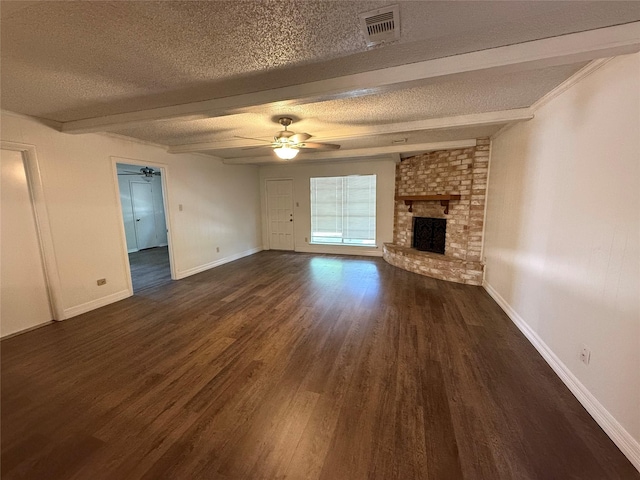 unfurnished living room with ceiling fan, dark wood-type flooring, beamed ceiling, a textured ceiling, and a fireplace