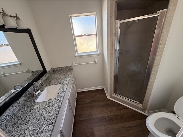 bathroom with hardwood / wood-style floors, vanity, toilet, and an enclosed shower