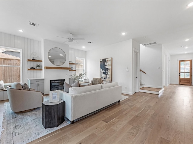 living room with light hardwood / wood-style flooring and ceiling fan