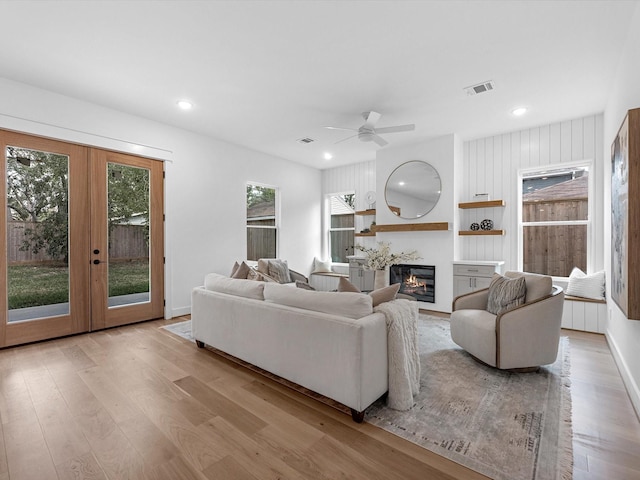 living room with ceiling fan, light wood-type flooring, and french doors