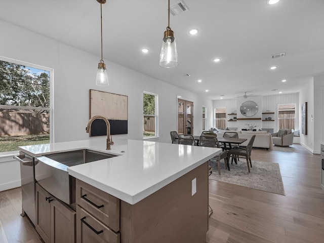 kitchen with sink, a healthy amount of sunlight, dark hardwood / wood-style flooring, and hanging light fixtures