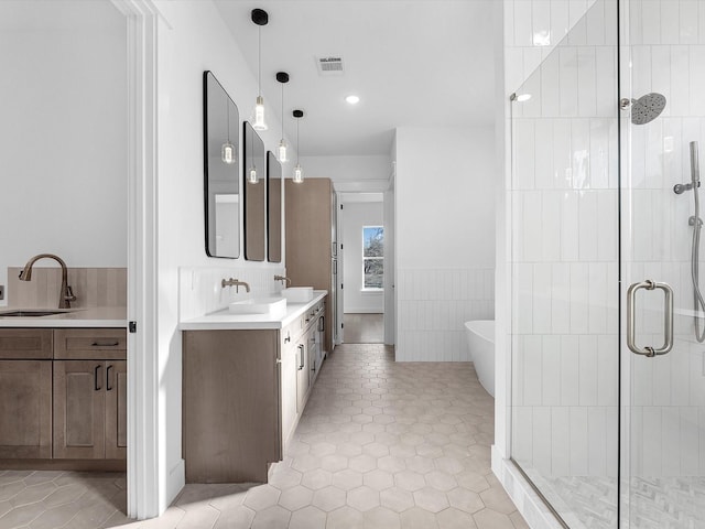 bathroom with tile patterned flooring, vanity, tile walls, and plus walk in shower