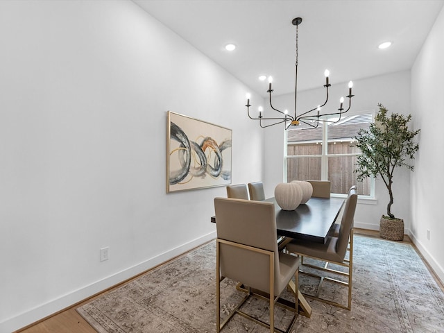 dining space with an inviting chandelier and hardwood / wood-style flooring