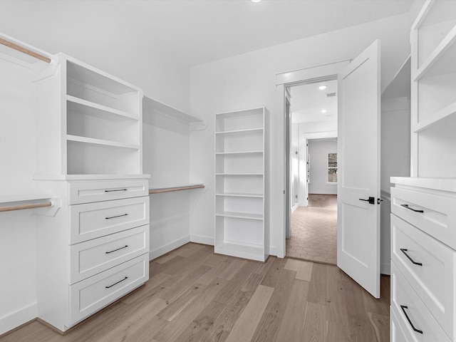 spacious closet featuring light hardwood / wood-style floors