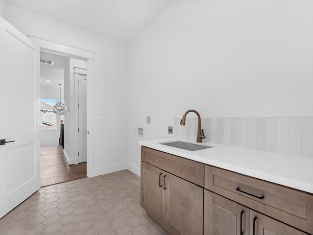 bathroom with hardwood / wood-style flooring, lofted ceiling, and sink