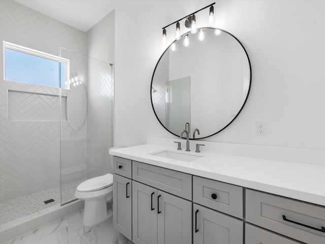 bathroom featuring vanity, toilet, and a tile shower