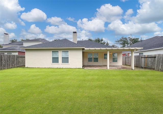 rear view of house with a lawn and a patio