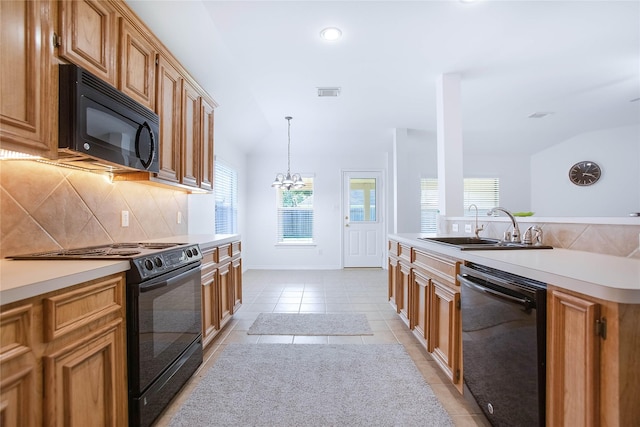 kitchen featuring lofted ceiling, black appliances, sink, light tile patterned floors, and decorative light fixtures