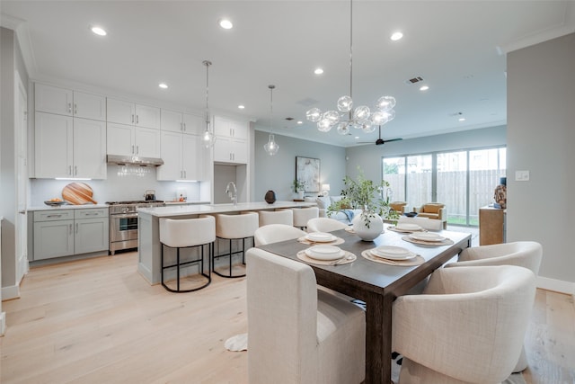 dining area featuring light wood-type flooring, ceiling fan, and crown molding