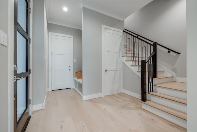 staircase featuring wood-type flooring and ornamental molding