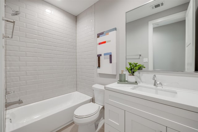 full bathroom with vanity, tiled shower / bath combo, and toilet