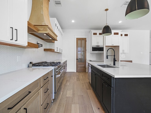 kitchen featuring white cabinets, sink, premium range hood, and stainless steel appliances