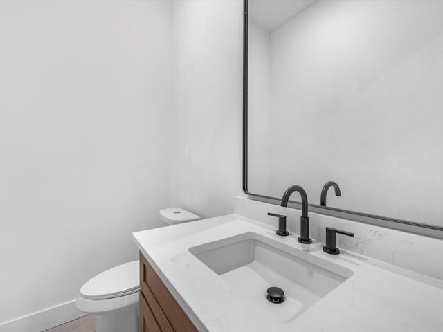 bathroom with tile patterned flooring, vanity, and toilet