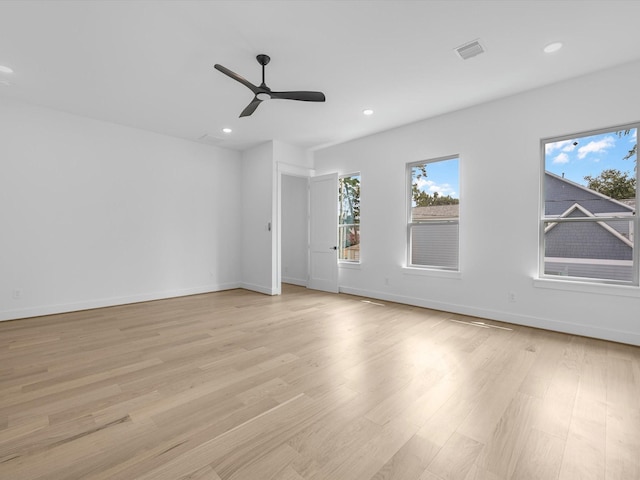 empty room with ceiling fan and light hardwood / wood-style flooring