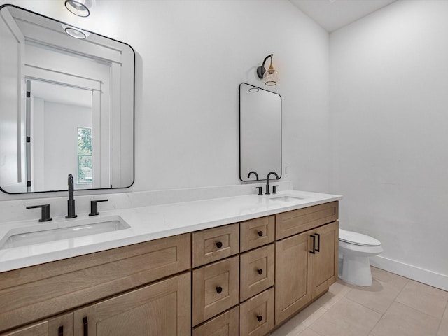 bathroom with toilet, vanity, and tile patterned floors