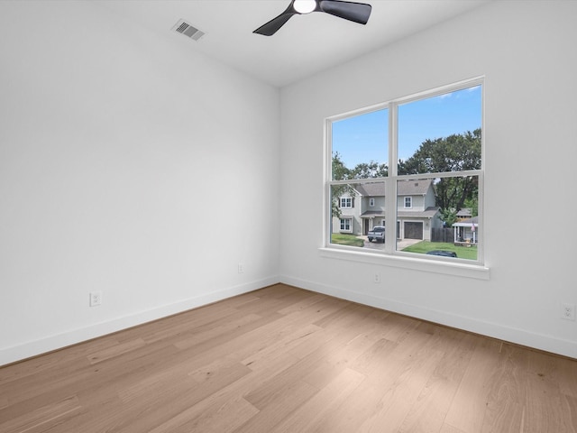 empty room featuring ceiling fan, a wealth of natural light, and light hardwood / wood-style flooring