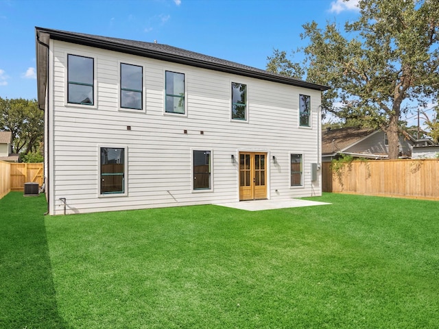 back of house featuring central air condition unit, a patio area, and a yard