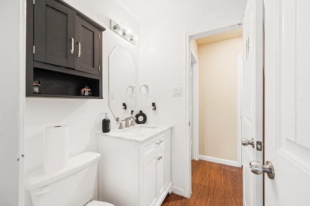 bathroom with vanity, wood-type flooring, and toilet