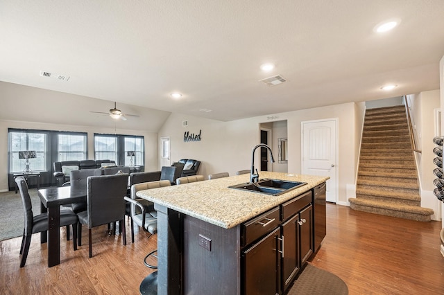 kitchen with hardwood / wood-style flooring, a center island with sink, ceiling fan, and sink