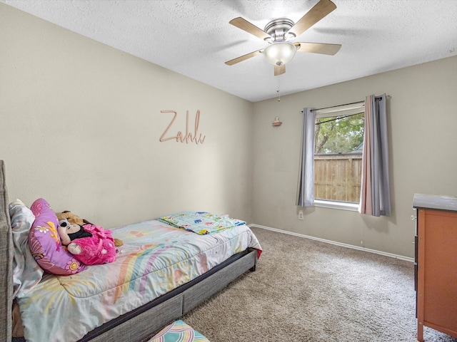 bedroom featuring ceiling fan, carpet floors, and a textured ceiling