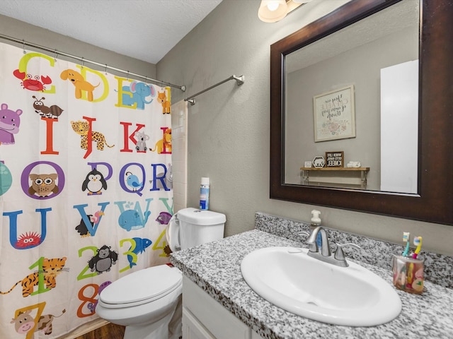 bathroom with a shower with curtain, vanity, a textured ceiling, hardwood / wood-style floors, and toilet