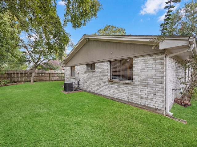 back of property with a lawn and central AC