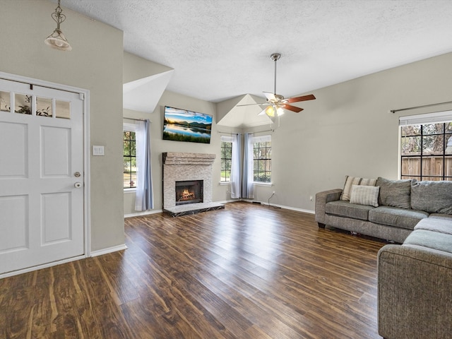 unfurnished living room featuring a textured ceiling, dark hardwood / wood-style floors, a wealth of natural light, and ceiling fan