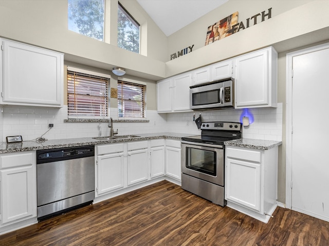 kitchen with white cabinets, high vaulted ceiling, sink, and appliances with stainless steel finishes