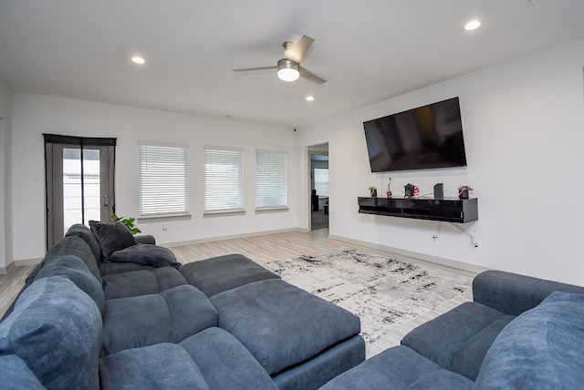 living room featuring ceiling fan and light hardwood / wood-style flooring