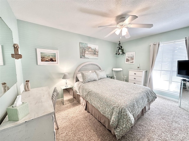 carpeted bedroom featuring multiple windows, ceiling fan, and a textured ceiling