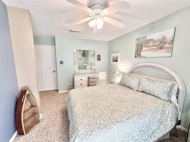 bedroom with ceiling fan, light carpet, and a textured ceiling