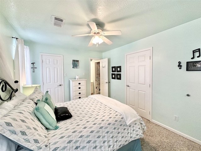 carpeted bedroom featuring a textured ceiling and ceiling fan