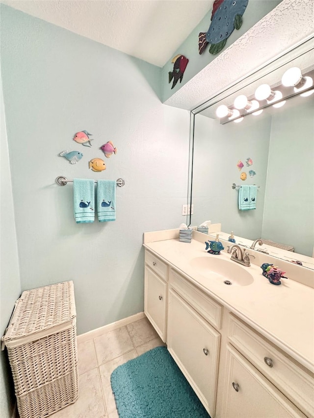 bathroom with tile patterned flooring, vanity, and a textured ceiling