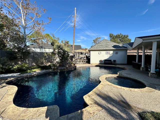 view of swimming pool with an in ground hot tub, an outdoor structure, and a patio area