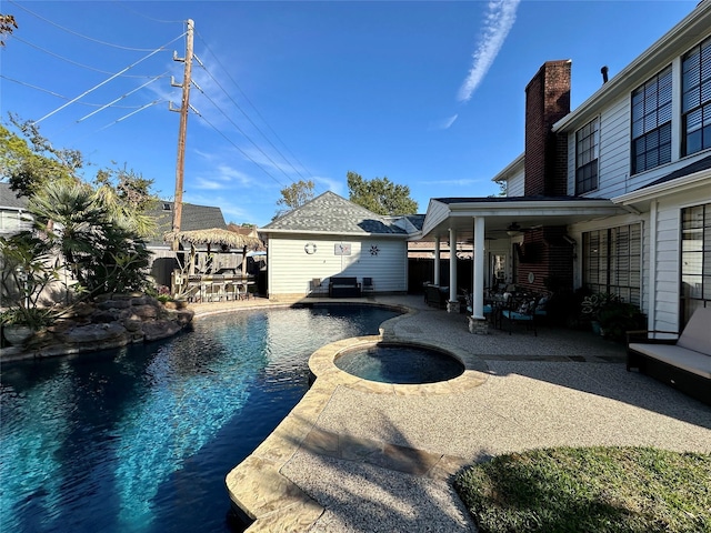 view of swimming pool with ceiling fan, an outdoor structure, an in ground hot tub, and a patio