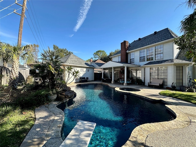 view of swimming pool featuring a patio area, an in ground hot tub, and a diving board