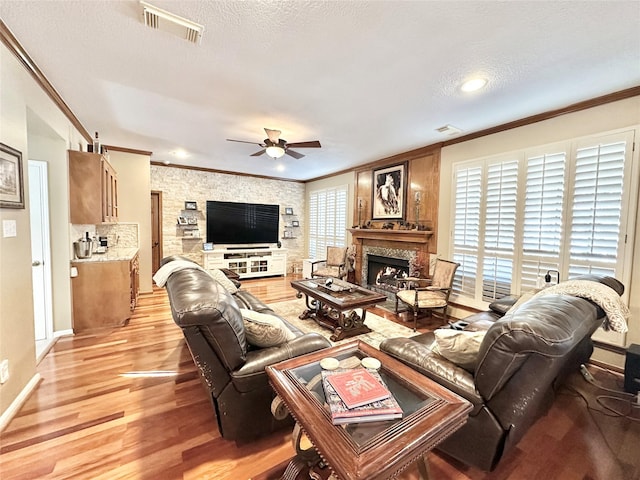 living room with ceiling fan, light hardwood / wood-style floors, ornamental molding, and a wealth of natural light