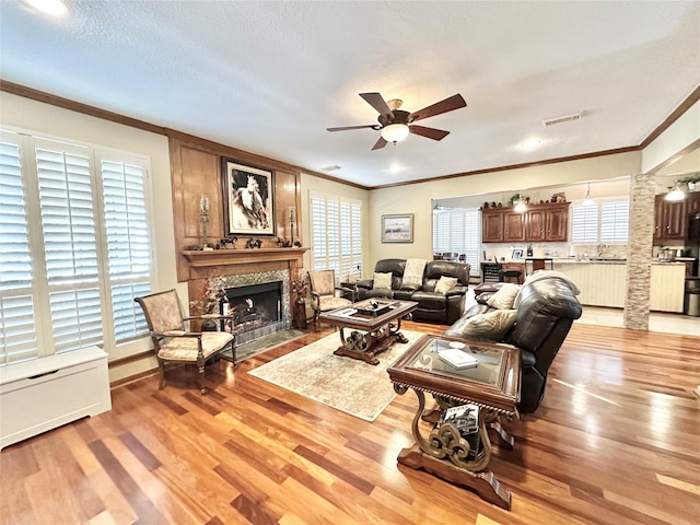 living room featuring light hardwood / wood-style floors, ceiling fan, and a healthy amount of sunlight