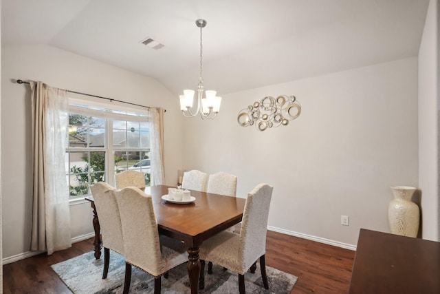 dining room featuring dark hardwood / wood-style flooring, lofted ceiling, and an inviting chandelier