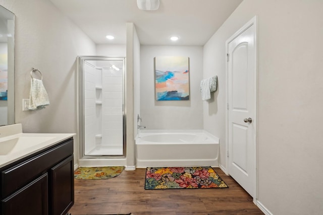 bathroom with hardwood / wood-style floors, vanity, and separate shower and tub