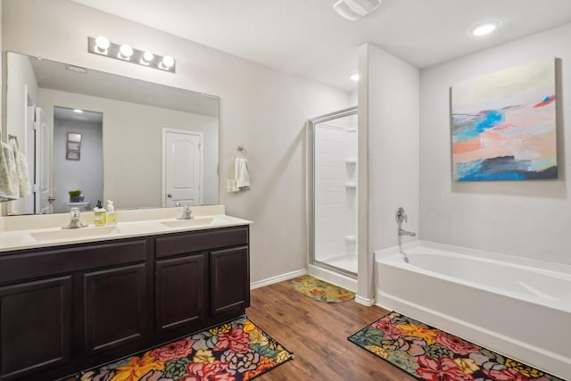 bathroom with wood-type flooring, vanity, and separate shower and tub